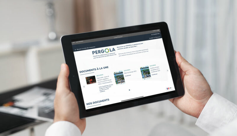 Homme consultant PERGOLA, la plateforme collaborative des professionnels du bâtiment en Outre-mer, sur sa tablette