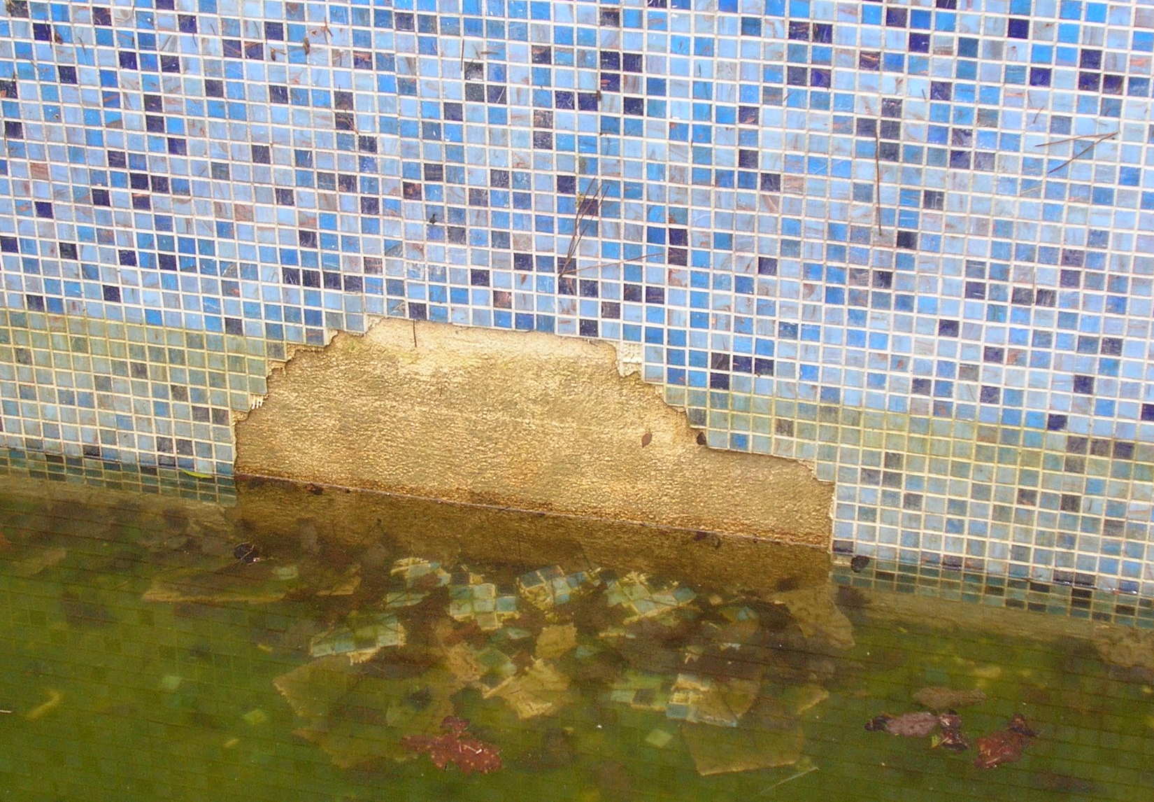 Décollement du revêtement mural en pâte de verre du bassin d'une piscine suite aux passages d’eau parasites