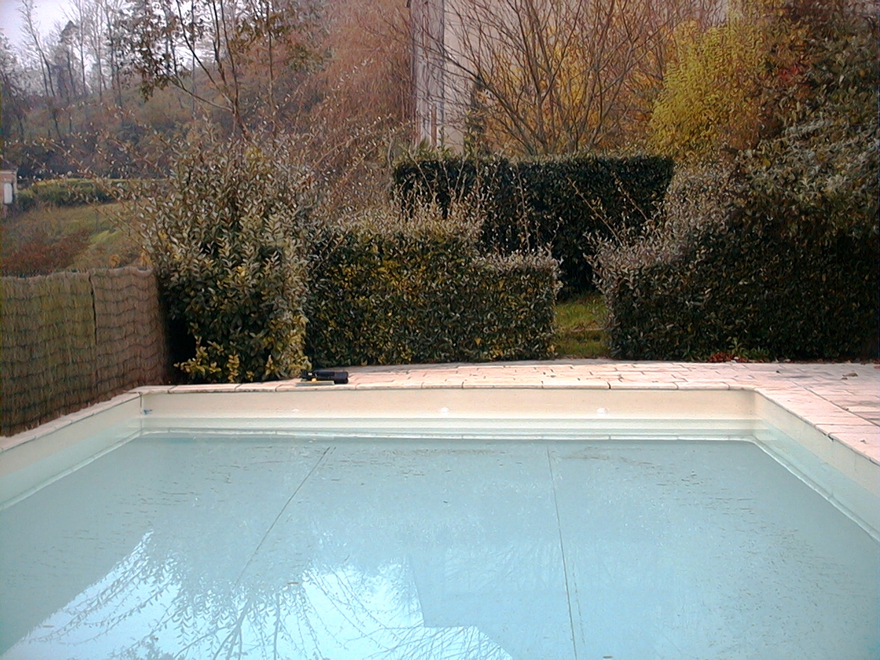 Structure endommagée d'une piscine, constituée d'un radier en béton et de parois en blocs de béton